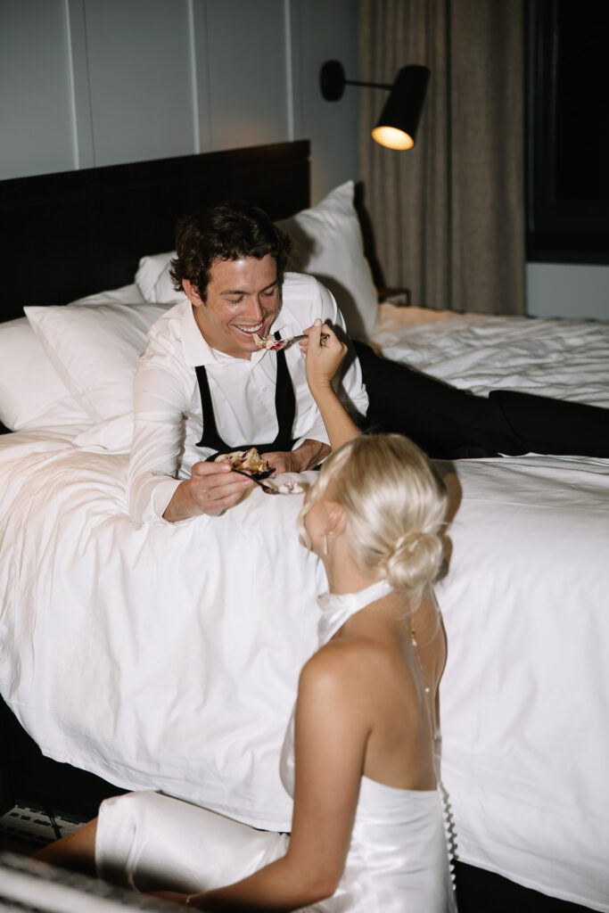 Bride playfully feeding cake to the groom.